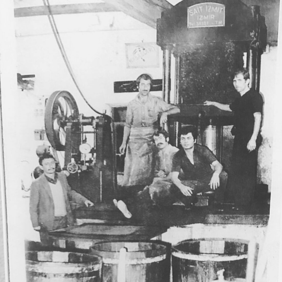 1960'lı yıllarda Yaşam Oliva'nın ilk hidrolik presinin başında duran beş işçinin siyah beyaz arşiv fotoğrafı